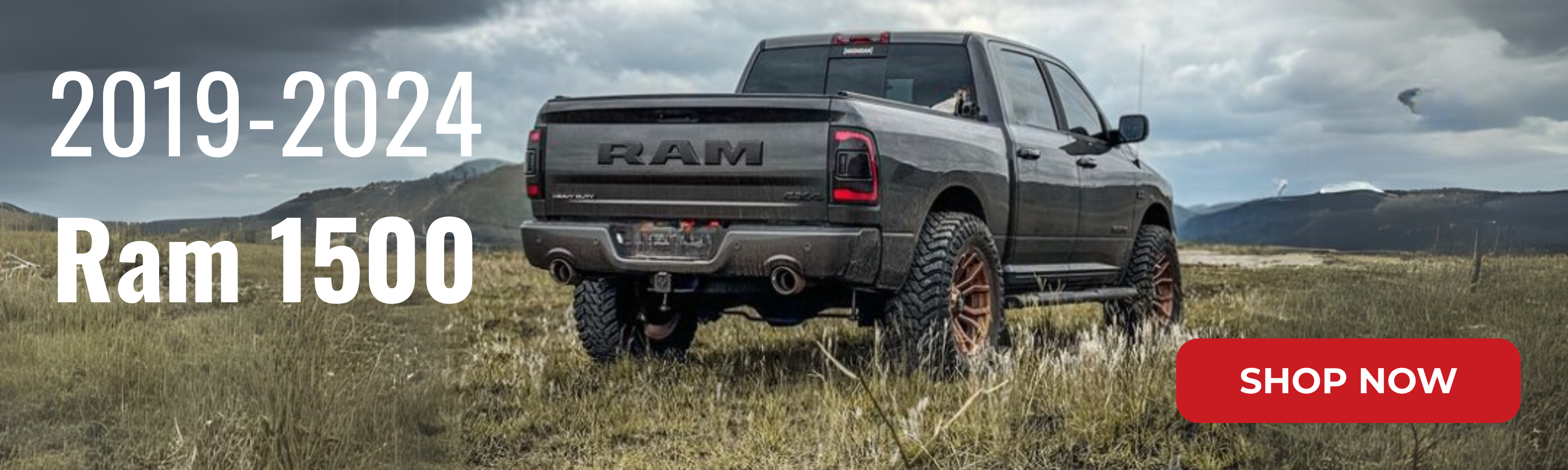 2024 Ram 1500 sitting in a field with oversized exhaust tips